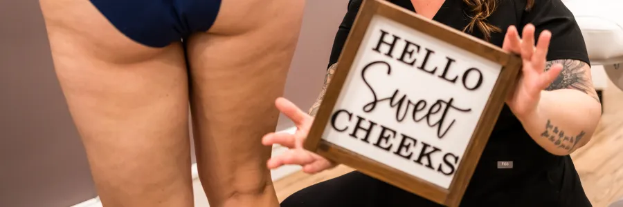 Brookes holding a sign that says sweet cheeks with a person showing a bum in blue underwear